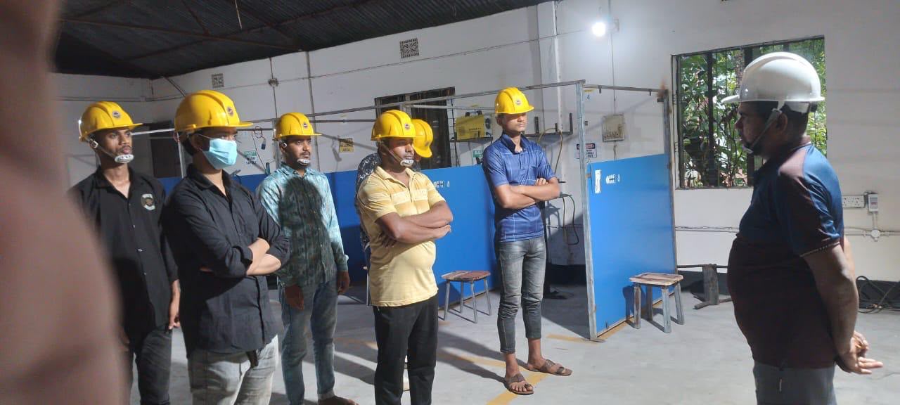 ওয়ার্কশপে ইনস্ট্রাক্টরের সামনে দাঁড়ানো শিক্ষার্থীদের দল